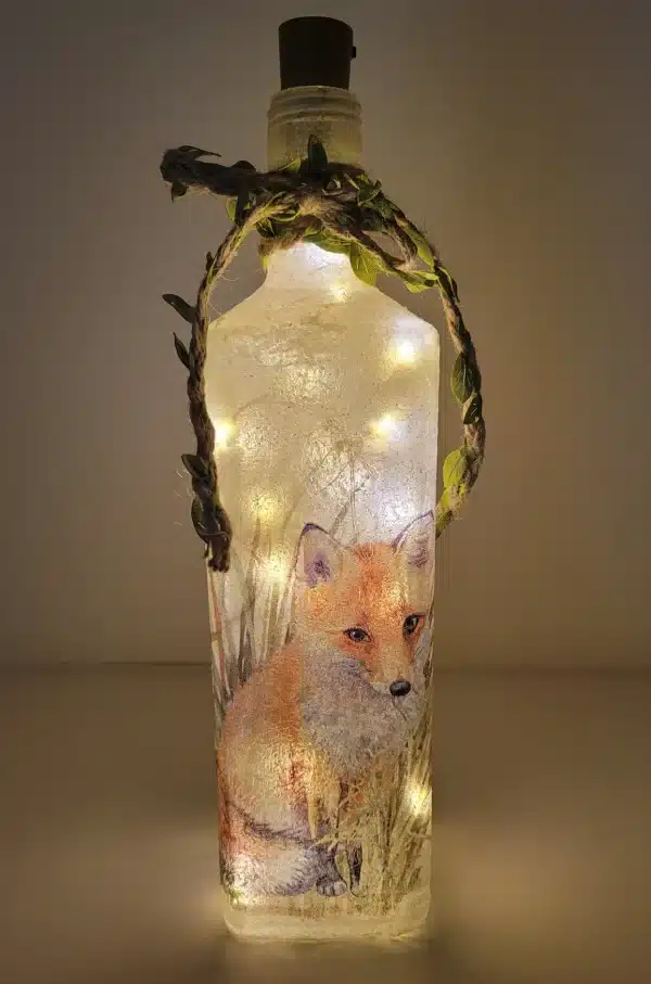 Lit up square gin bottle with fox detail and jute twine with leaves. Cork LED lights