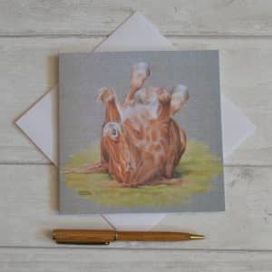 Art card from an acrylic painting. Suffolk Punch horse rolling on its back with feet in the air, on a grey background. Square card, blank inside, with envelope.