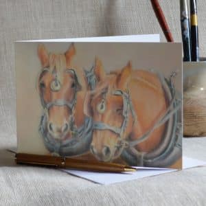 Art greetings card. Pair of chestnut Suffolk Punch heavy horse heads in harness with pale background.