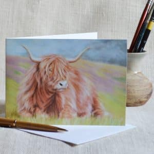 Highland Cow art greetings card. Cow lying down in Scottish landscape. Blank inside.